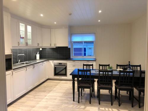 a kitchen with a black table and chairs in it at Balestrand Fjordapartments in Balestrand