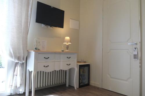 a room with a dresser with a tv on the wall at Romantic Home in Sirmione
