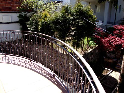 a metal bridge over a walk way with flowers at Demi Old Town - Garage Parking in Sarajevo