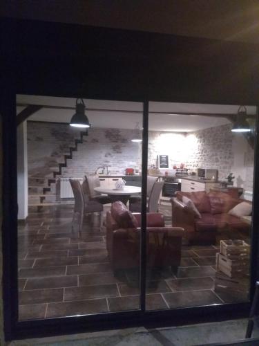 a living room with couches and a table and a kitchen at Oclos du RhuisO in Rhuis
