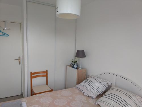 a bedroom with a bed with a pillow and a chair at Via Calanca in Marseille