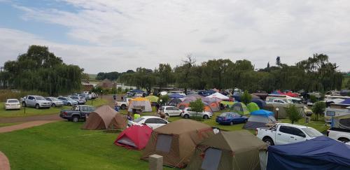 a parking lot full of tents and parked cars at Umuzi Lodge in Secunda