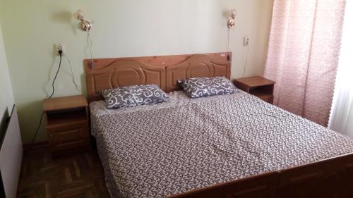 a bed with two pillows on it in a bedroom at КП ДР Готель in Drohobytsch