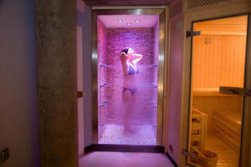 a woman standing in a shower in a room at Hotel Spa QH Centro León in León