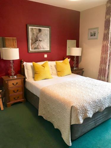 a bedroom with a large bed with yellow pillows at The Lantern Townhouse in Dingle