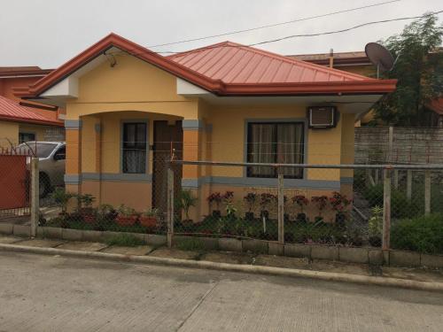 a yellow house with a fence in front of it at Jireh’s Guests Home in Butuan