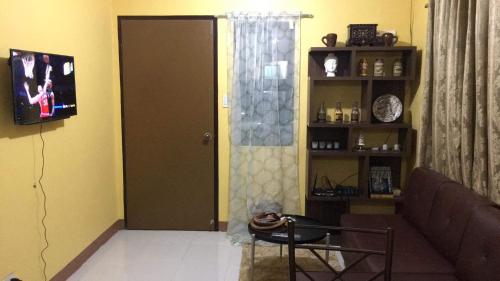 a living room with a couch and a book shelf at Jireh’s Guests Home in Butuan
