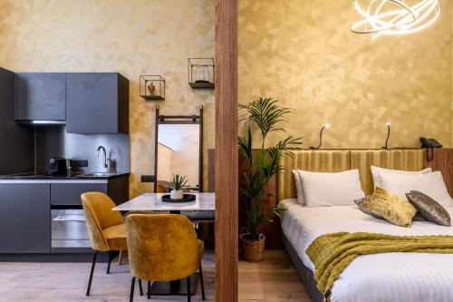 a bedroom with a bed and a table and a kitchen at Leopold Hotel Oudenaarde in Oudenaarde