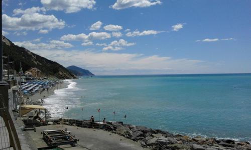 a beach with chairs and people on the water at Come a casa in Deiva Marina