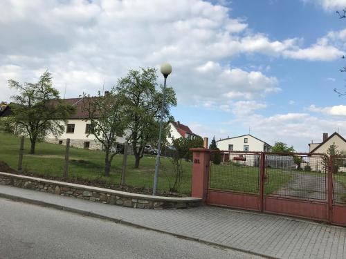 a red fence with a street light next to a yard at Rozboudovec in Křemže