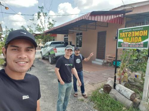 a group of men standing in front of a building at HOMESTAY AQILAH PASIR PUTEH KELANTAN in Pasir Puteh