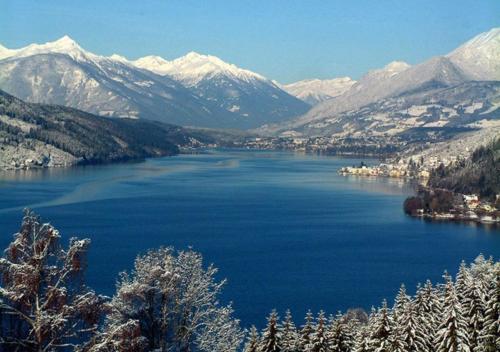 a view of a lake with snow covered mountains at Ferienhaus Döbriach am Millstätter See in Döbriach