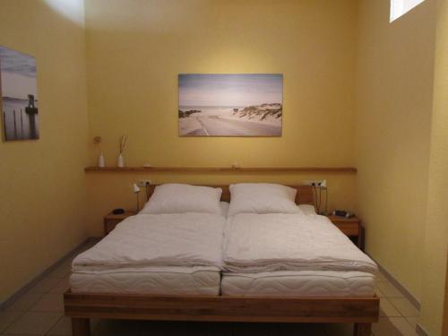 Una cama con sábanas blancas y almohadas en una habitación. en Fewo Koje 22, en Ostseebad Karlshagen