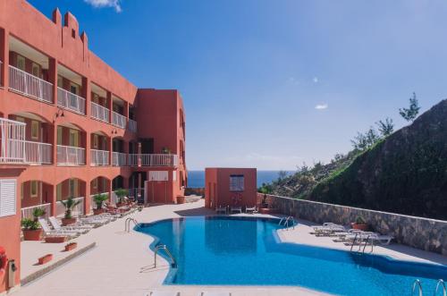 a hotel with a swimming pool next to a building at Playa Paraiso-Apartment 4 you in Costa Calma
