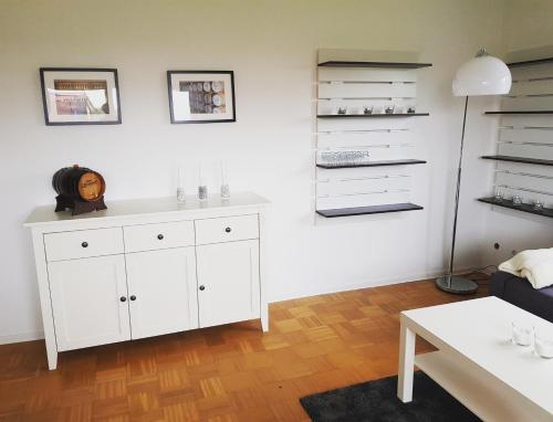 een woonkamer met een witte kast en een tafel bij Ferien in Neuffen - Ferienwohnung Plaue in Neuffen