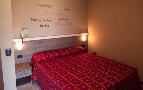 a bedroom with a bed with a red comforter at Albergo Ristorante Monterosa in Ameno
