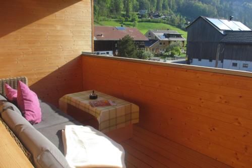 a balcony with a couch and a table and a window at Ferienwohnung Greber Regina in Bezau