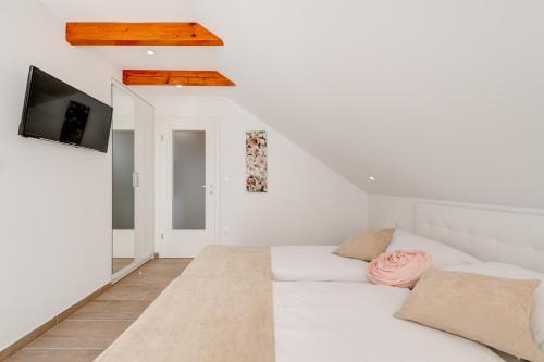 a white room with a bed and a tv at Apartments Villa Tudor in Hvar