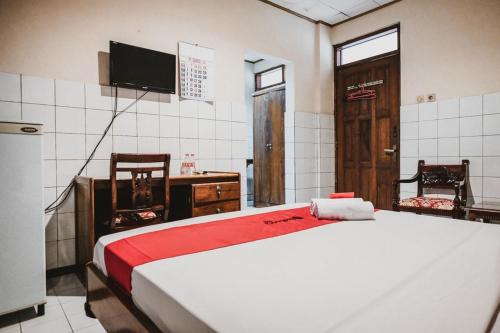 um quarto com uma cama e uma televisão em RedDoorz @ Ungaran em Semarang