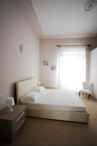 a bedroom with a bed and a window with a chair at La Mela Rosa in Valentano
