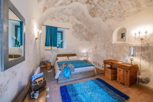 菲納萊利古雷的住宿－Locanda La Fortezza，一间卧室配有一张床和蓝色地毯