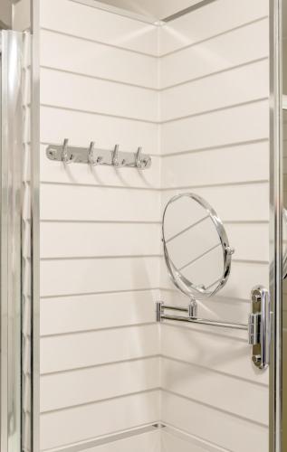 a shower with a round mirror on the wall at Apartments Villa Tudor in Hvar