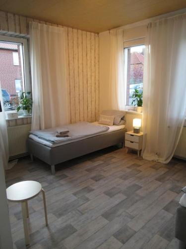 a small bedroom with a bed and two windows at Tolle Lage Hannover Braunschweig Wolfsburg in Leiferde
