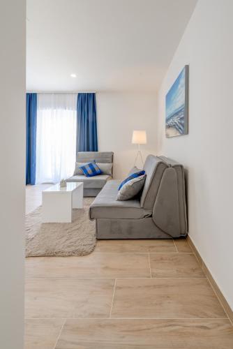 a living room with a couch and a table at Apartments Villa Tudor in Hvar
