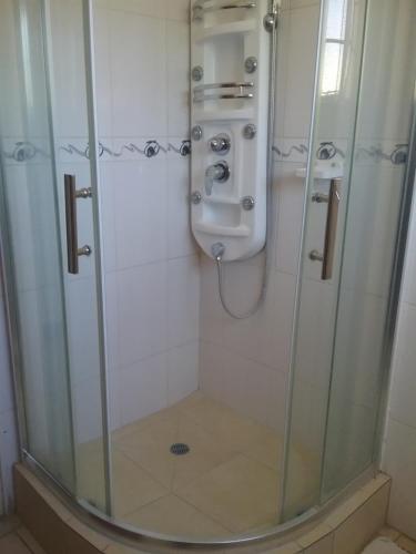 a bathroom with a shower with a sink and a urinal at The Star B&B in Jwaneng