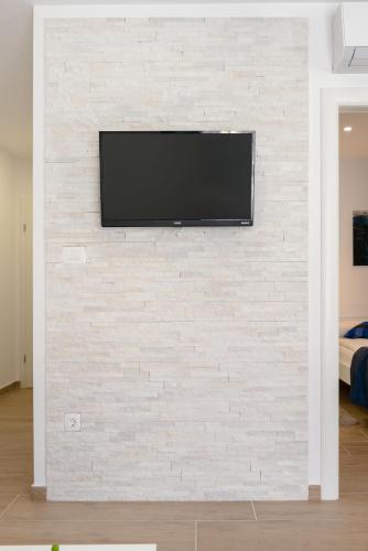 a wall with a tv on a brick wall at Apartments Villa Tudor in Hvar