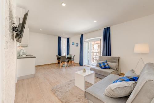 a living room with a couch and a table at Apartments Villa Tudor in Hvar