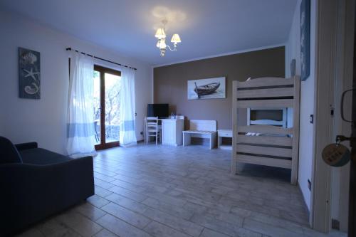 a living room with a bed and a room with a table at Club Esse Sporting in Stintino