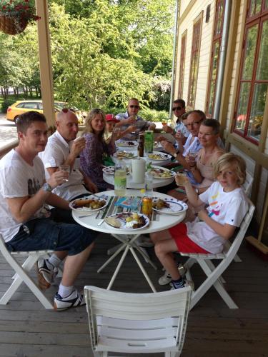 a group of people sitting around a table on a porch at Ronneby Brunnspark Vandrarhem och B&B in Ronneby