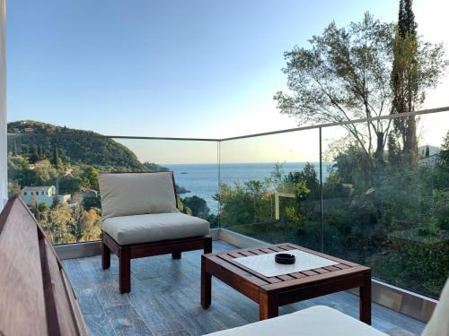 a balcony with a chair and a coffee table at Rokamare Beach Resort in Liapades