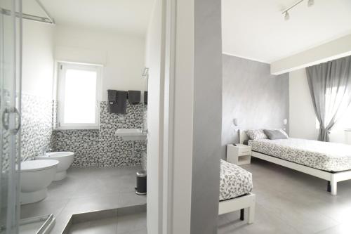 biała łazienka z łóżkiem, toaletą i umywalką w obiekcie SaMi B&B w mieście Scalea