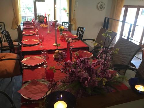 a long table with red tablecloths and flowers on it at Schwanenvilla in Paraza