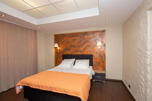 a bedroom with a large bed with an orange blanket at P54 Apartment in Paide