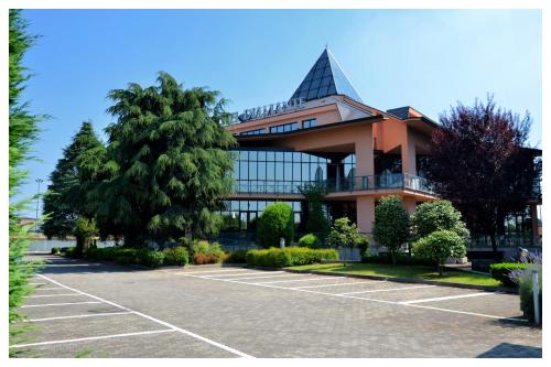 a large building with a parking lot in front of it at Hotel Diamante in Corbetta