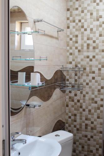 a bathroom with a sink and a toilet and a mirror at Guest House Valiland in Bŭlgarevo