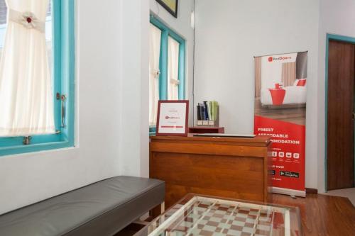 a room with a bed and a dresser and a window at RedDoorz @ Kartohardjo Madiun in Madiun