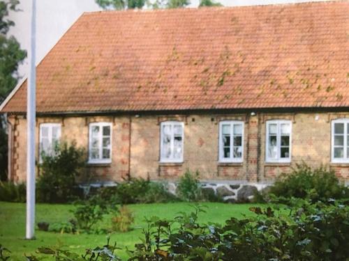 an old brick house with a red roof at Liv på Österlen Bed&Breakfast in Sandby