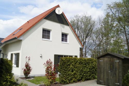 a white house with a brown roof at Ferienhaus Buche im Land Fleesensee in Göhren-Lebbin