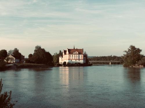 a house on an island in the middle of a river at Appartementhof Stadler in Pocking