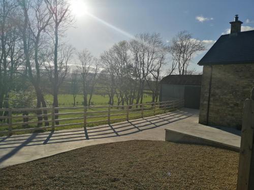 a fence in front of a field with trees at Knockninny Barn at Upper Lough Erne, County Fermanagh in Enniskillen