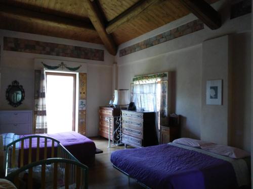 sypialnia z 2 łóżkami, komodą i oknem w obiekcie Antico Casale dei Sogni agriturismo w mieście Lugo