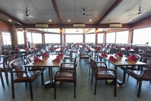 a room with tables and chairs with red napkins on them at Upper Deck Resort - Stay and Relax at the Highest Peak Lonavala in Lonavala