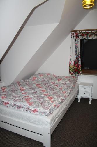 a bed sitting in a room with a window at Leśny Dworek 1 in Wołkowyja
