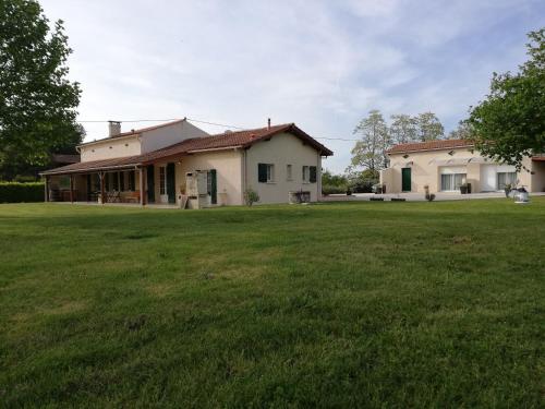 una casa con un gran patio delante de ella en La Mancine Laulan, en Jau-Dignac-et-Loirac