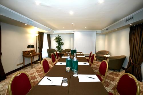 a conference room with long tables and red chairs at Sina De La Ville in Milan