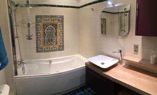 a bathroom with a tub and a toilet and a sink at La Prévôté in Marchenoir